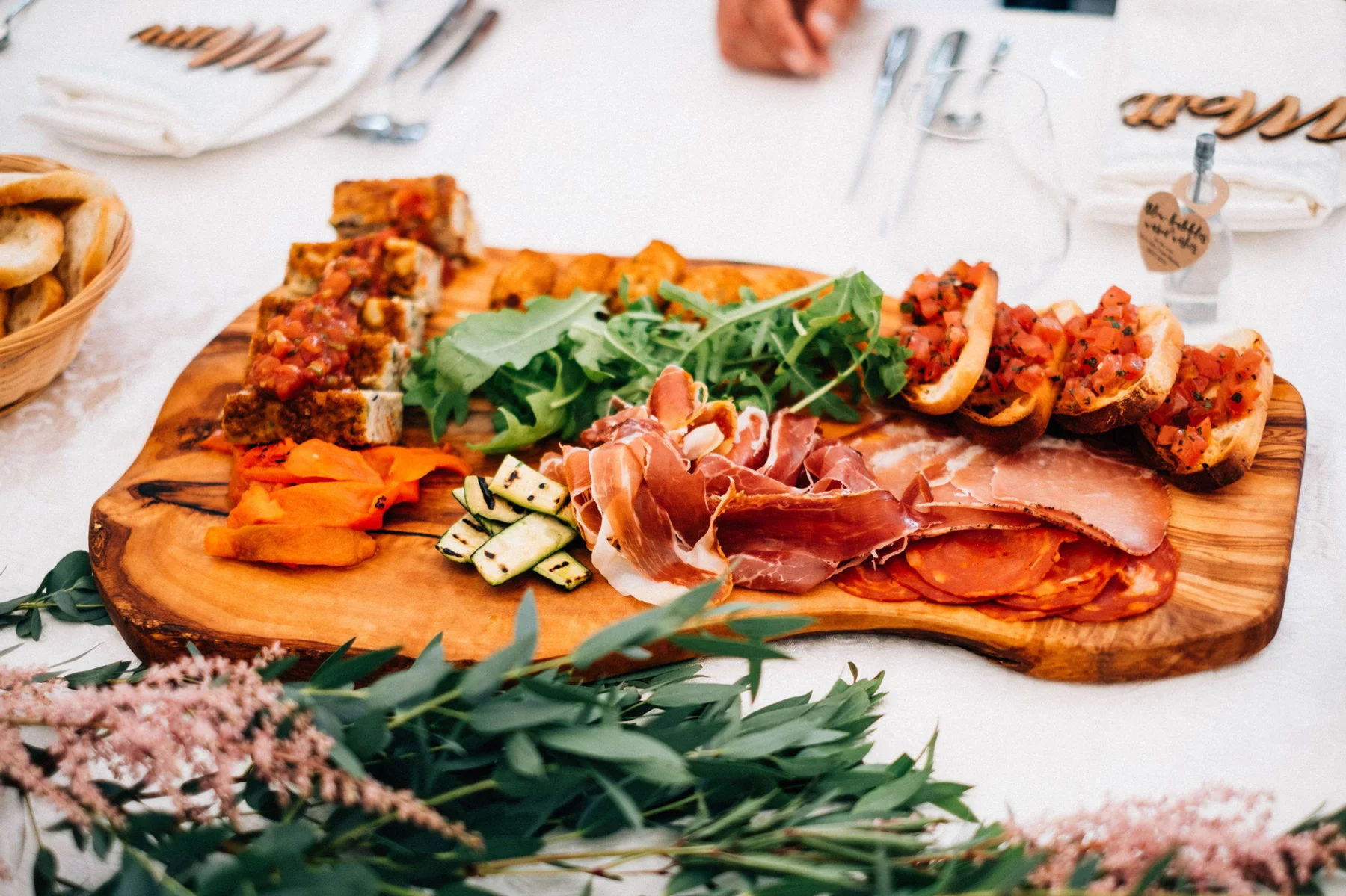 A charcuterie board dressed with figs, honey and warm bread
